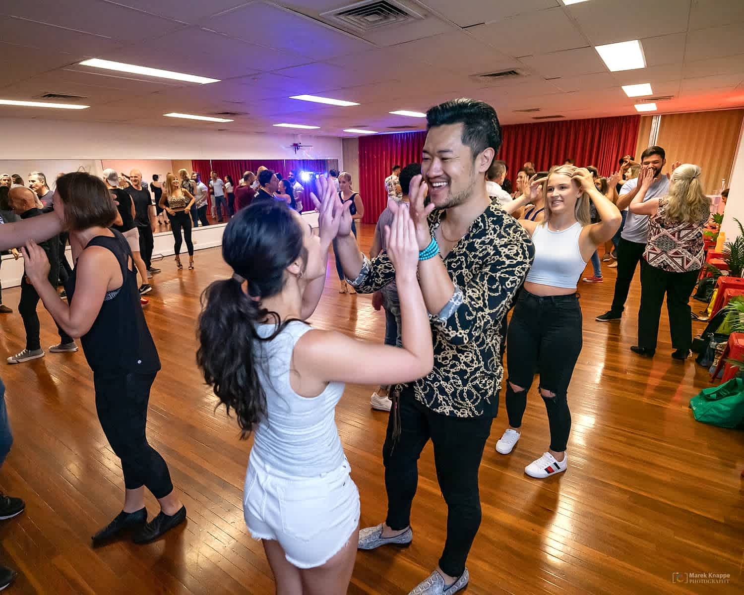 A full Introduction to Latin Dancing class high-fiving and changing partners