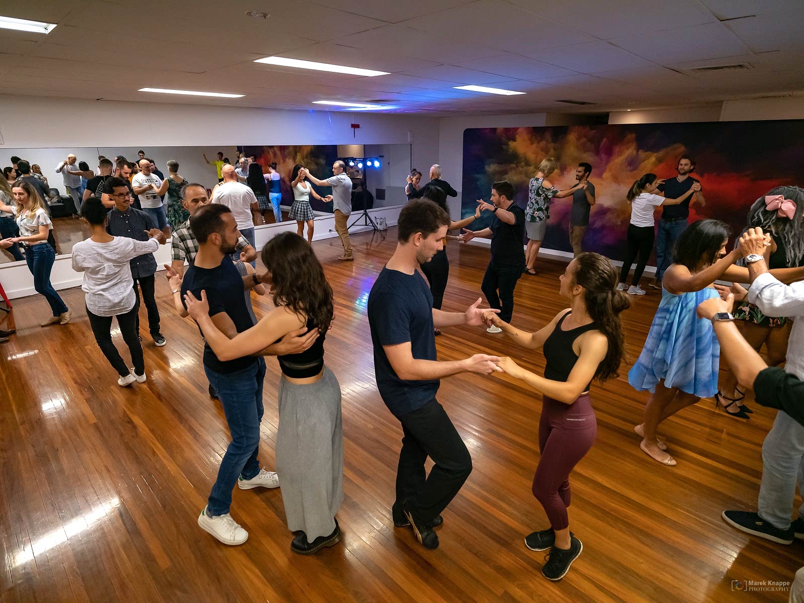 Studio 2 at Dance Culture Annerley: dancers on the hardwood floor in front of mirrors and a colourful mural wall