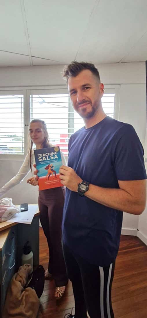 A Dance Culture instructor holding the Teaching Salsa paperback
