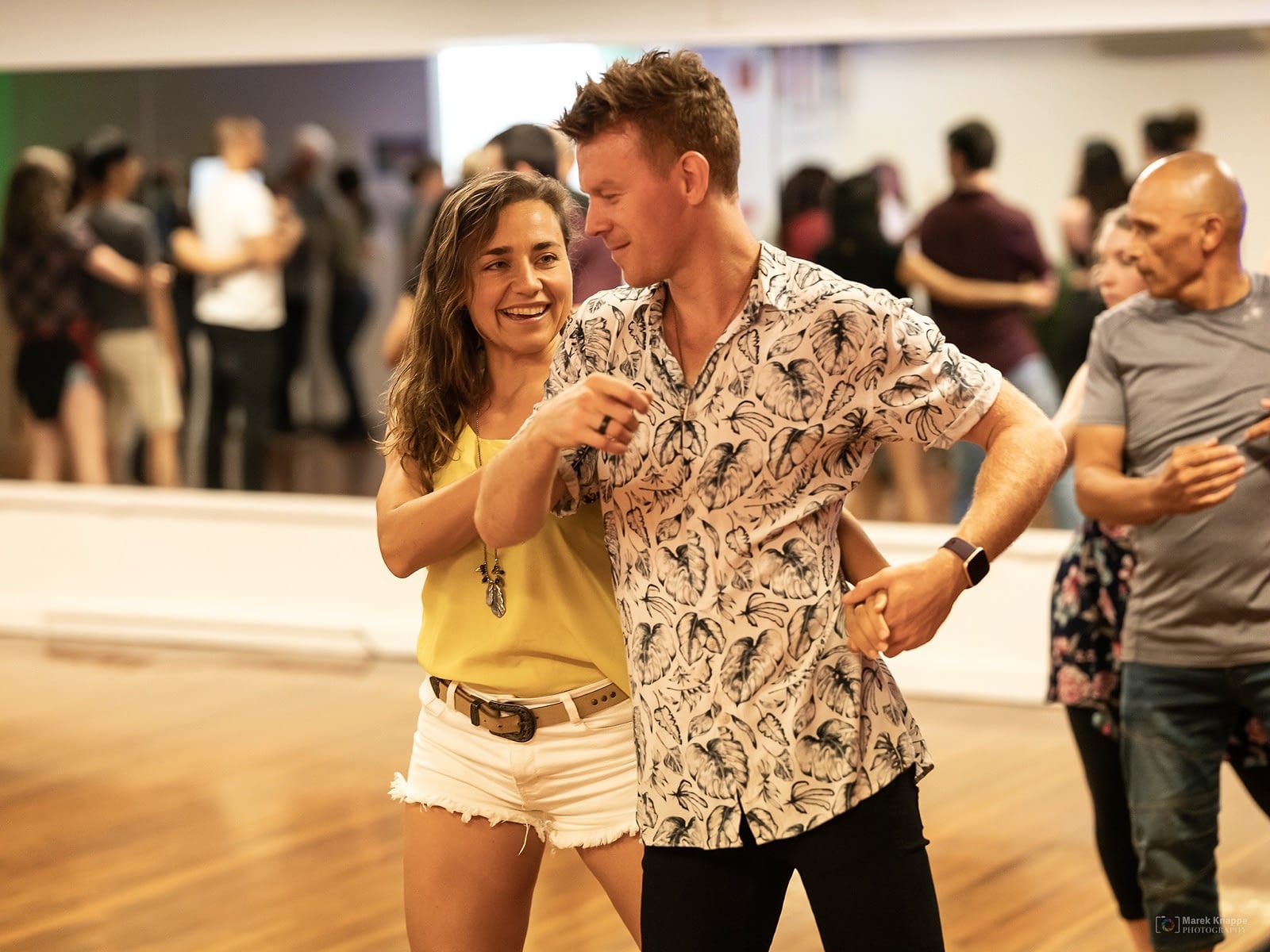 Two students laughing together while dancing